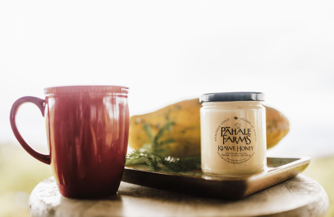 A red mug and a jar of honey